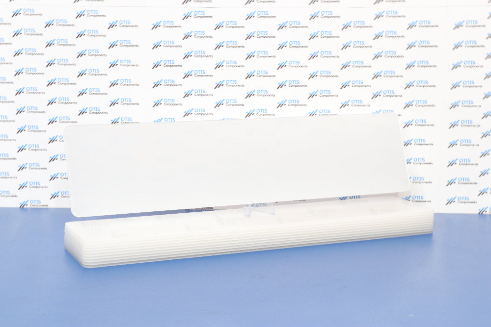 A single white acrylic number plate blank laid out on a flat surface, with multiple plates visible in the background.